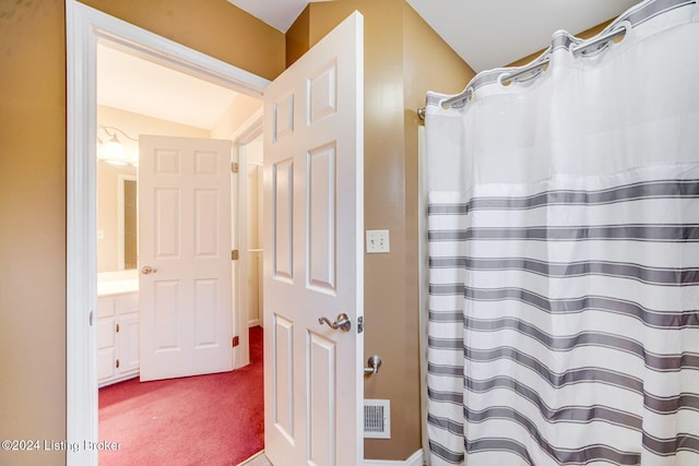 bathroom featuring visible vents, lofted ceiling, and a shower with shower curtain