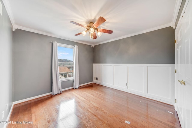 empty room featuring light wood-type flooring, ornamental molding, and a ceiling fan