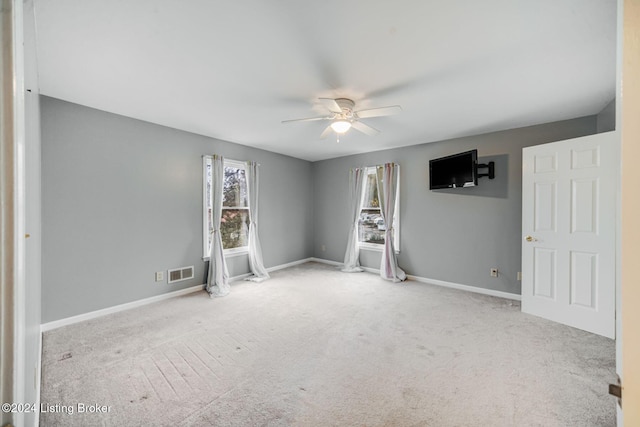 unfurnished room with baseboards, visible vents, a ceiling fan, and carpet floors