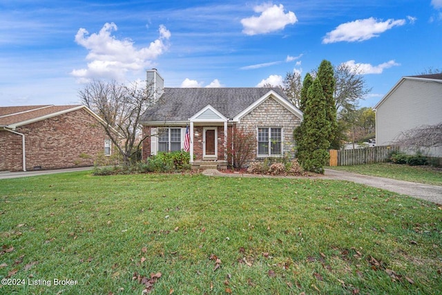 view of front of home with a chimney, fence, a front yard, and stone siding