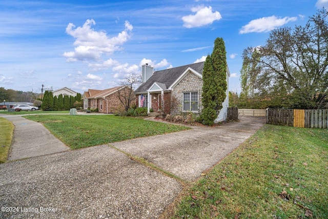bungalow-style house featuring driveway, stone siding, a chimney, fence, and a front lawn
