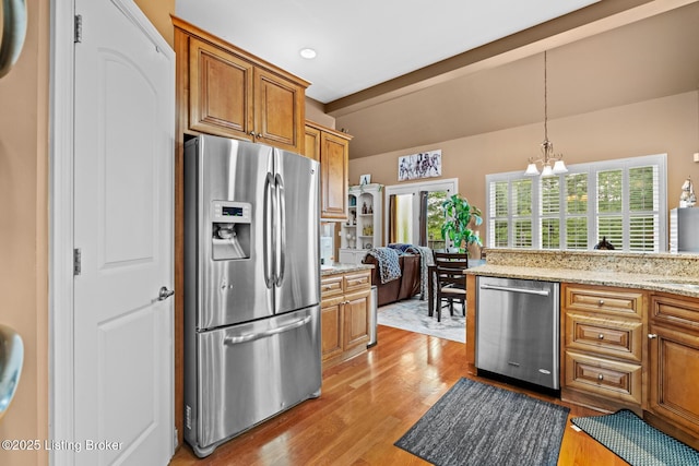 14729 Forbes Cir, Louisville, KY 40245 - kitchen with light wood finished floors, an inviting chandelier, brown cabinetry, vaulted ceiling, and appliances with stainless steel finishes