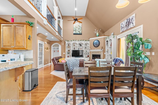 14729 Forbes Cir, Louisville, KY 40245 - dining space featuring ceiling fan, light wood-style floors, baseboards, a fireplace, and high vaulted ceiling
