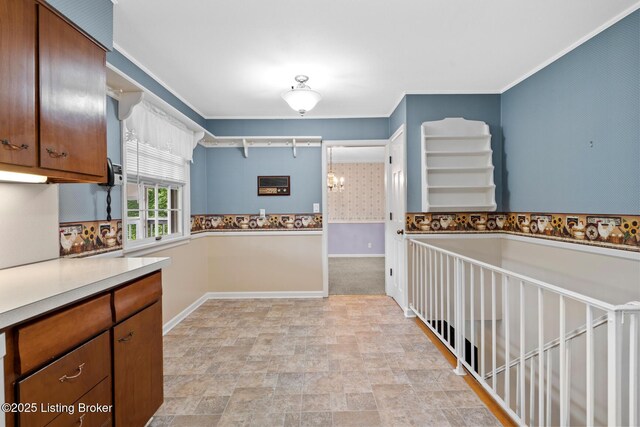 9111 Royal Oak Dr, Louisville, KY 40272 - kitchen with stone finish floors, brown cabinetry, baseboards, and light countertops