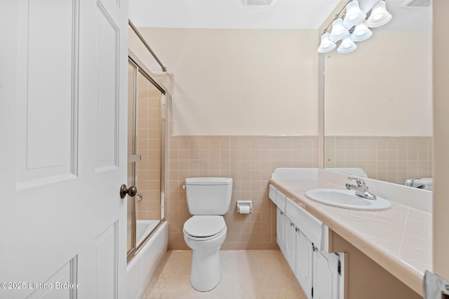 9111 Royal Oak Dr, Louisville, KY 40272 - full bathroom featuring vanity, toilet, tile walls, a wainscoted wall, and combined bath / shower with glass door