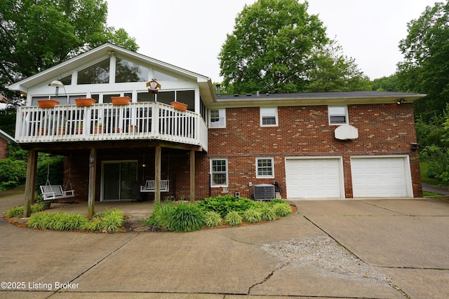 9111 Royal Oak Dr, Louisville, KY 40272 - back of house featuring a garage, central AC unit, brick siding, and driveway