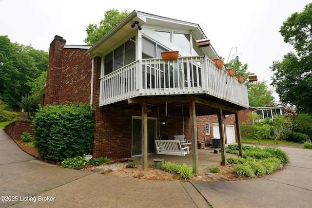 9111 Royal Oak Dr, Louisville, KY 40272 - view of side of home featuring brick siding, a chimney, a sunroom, and a wooden deck