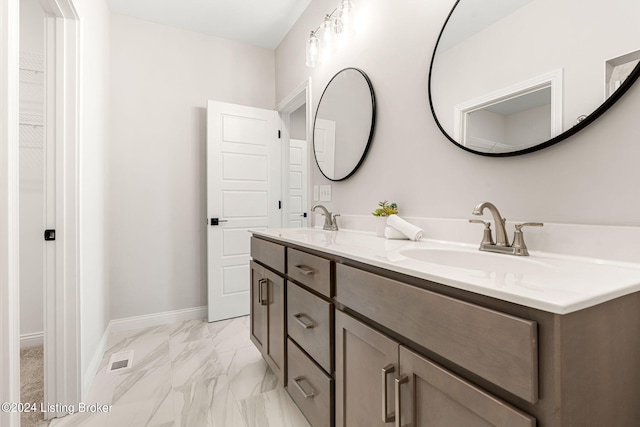 bathroom with double vanity, baseboards, marble finish floor, and a sink