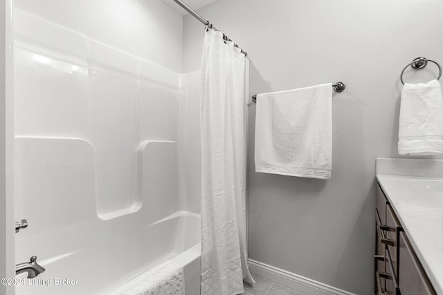 bathroom featuring baseboards, shower / bathtub combination with curtain, and vanity