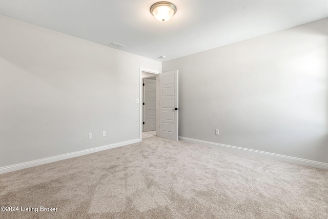 carpeted spare room featuring visible vents and baseboards