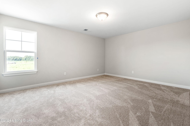 empty room featuring carpet flooring, baseboards, and visible vents