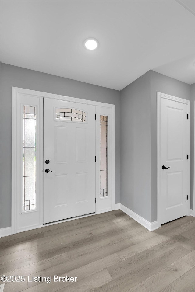 entrance foyer with baseboards and light wood-style floors