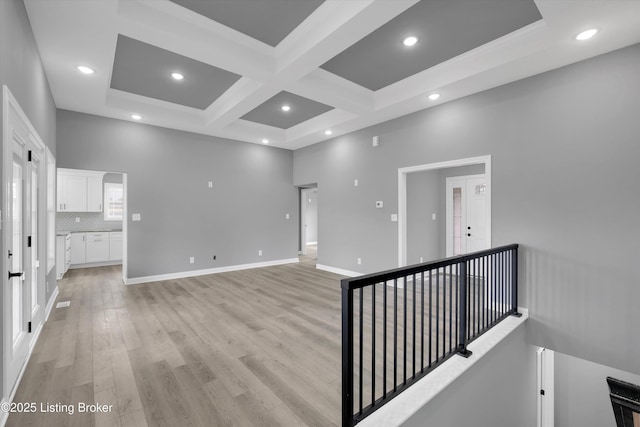unfurnished room with beamed ceiling, recessed lighting, light wood-style floors, coffered ceiling, and baseboards