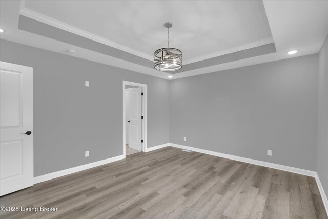 unfurnished room featuring crown molding, recessed lighting, a raised ceiling, and baseboards