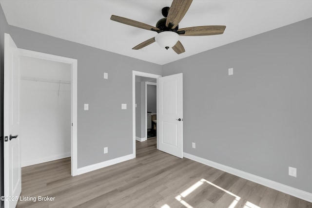 unfurnished bedroom featuring a closet, wood finished floors, and baseboards