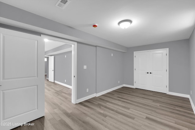 below grade area featuring visible vents, wood finished floors, and baseboards