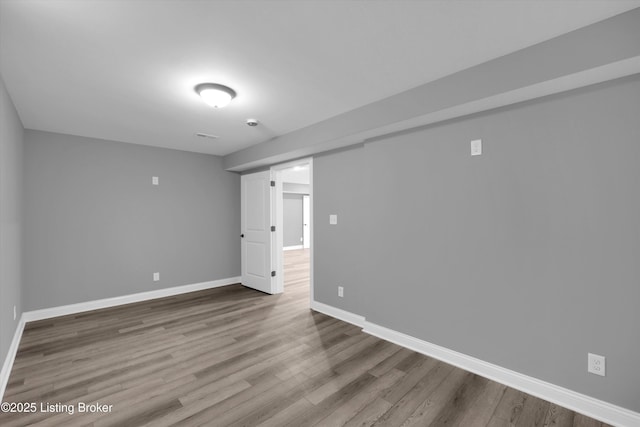 finished below grade area featuring wood finished floors and baseboards