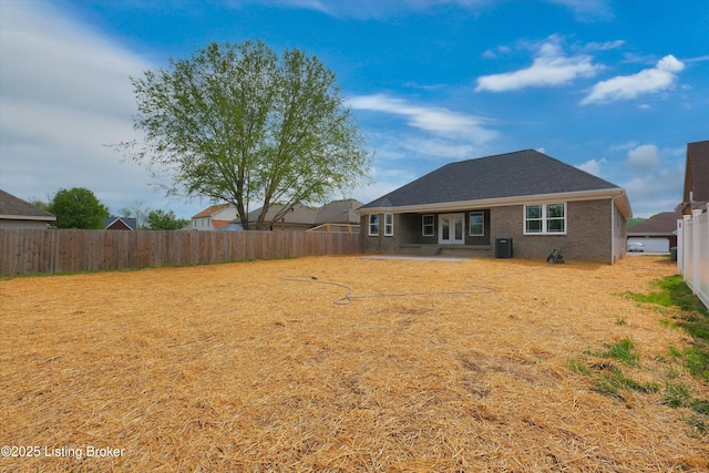 rear view of property featuring a patio, central AC, a fenced backyard, and brick siding