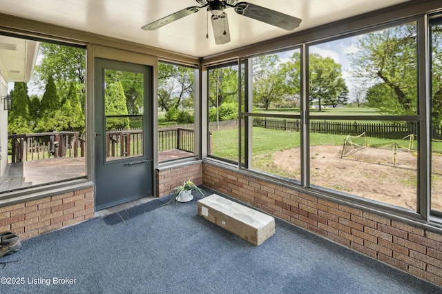 unfurnished sunroom featuring a ceiling fan