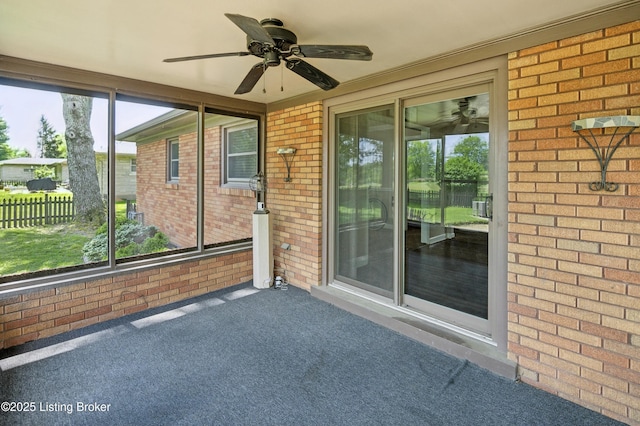 unfurnished sunroom featuring ceiling fan