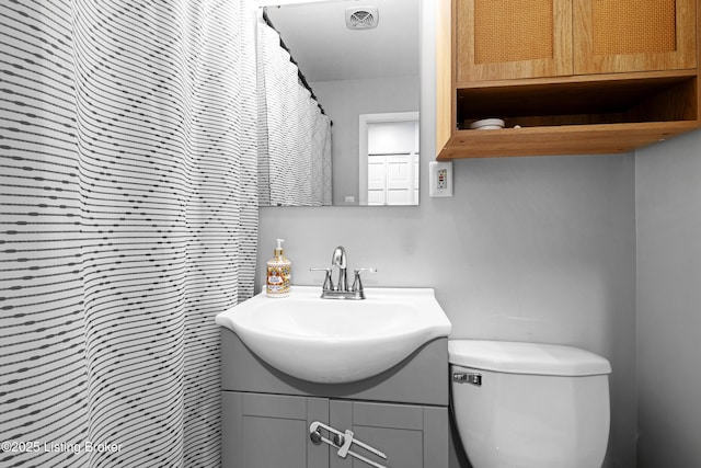 full bathroom with toilet, visible vents, and vanity