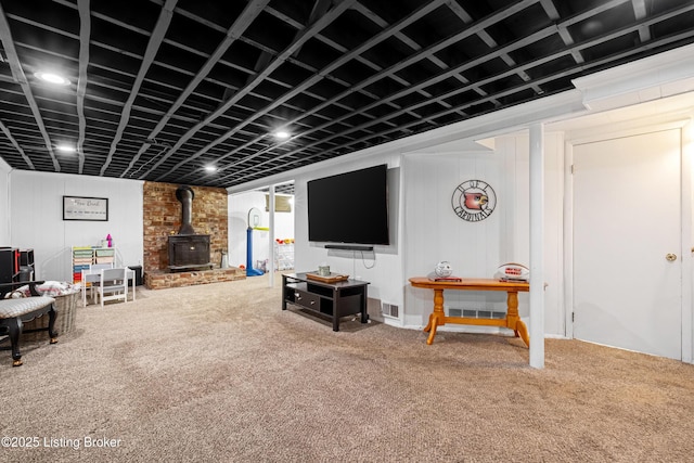 carpeted living area with visible vents and a wood stove