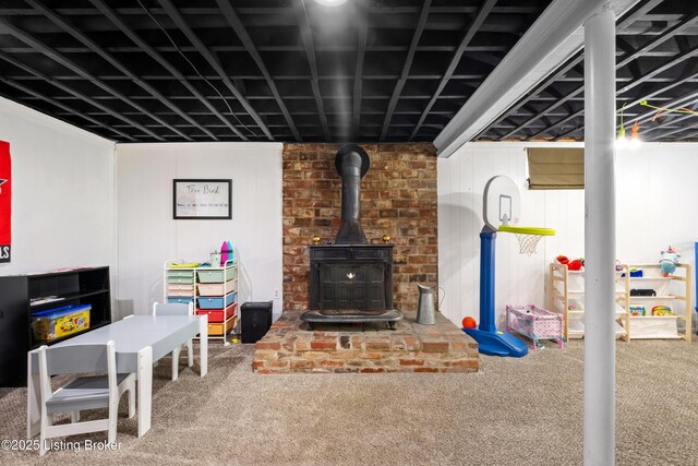 carpeted living room with a wood stove