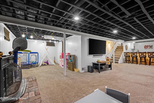 finished basement featuring visible vents, bar area, carpet flooring, and stairs