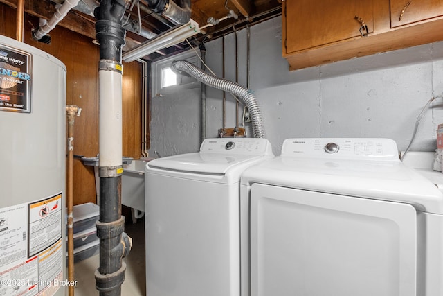 washroom with water heater, laundry area, and washer and clothes dryer