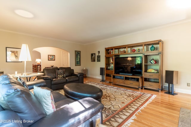 living room featuring crown molding, light wood-style flooring, and arched walkways