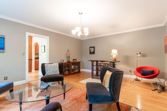 living area with light wood-type flooring, arched walkways, a notable chandelier, and crown molding