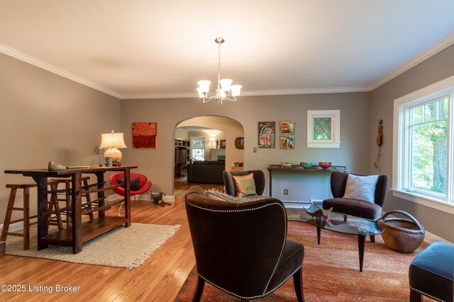living room featuring crown molding, arched walkways, a chandelier, and wood finished floors