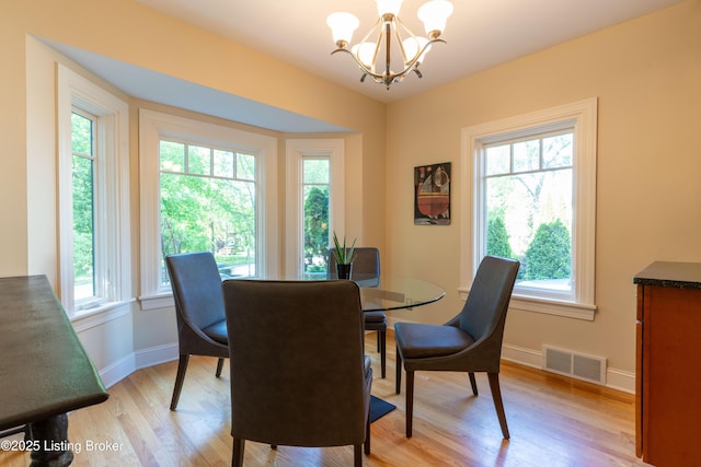 dining area with a wealth of natural light, visible vents, and a notable chandelier
