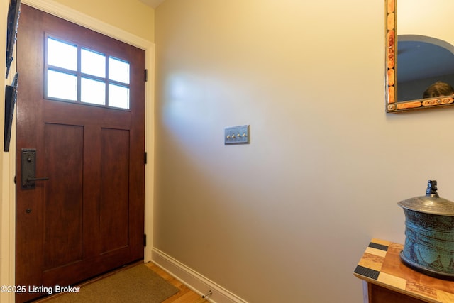 doorway to outside featuring wood finished floors and baseboards