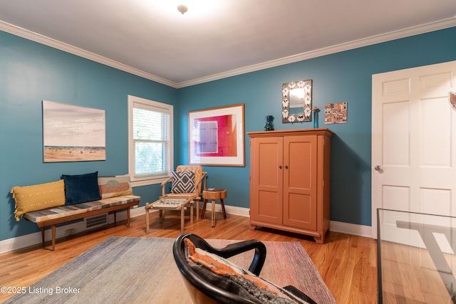 sitting room featuring baseboards, light wood-style floors, and crown molding