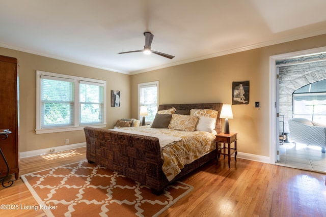 bedroom featuring ornamental molding, ceiling fan, baseboards, and light wood-style floors