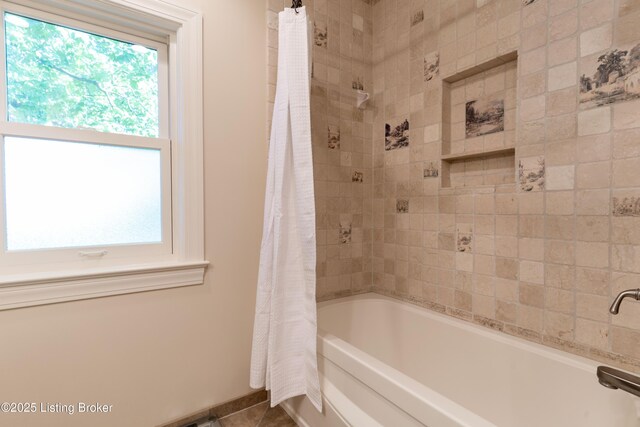 bathroom with shower / bath combo, tile patterned floors, and baseboards