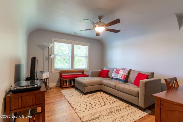 living area with visible vents, light wood-type flooring, a ceiling fan, and baseboards