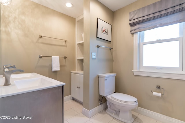 bathroom featuring toilet, tile patterned flooring, vanity, and baseboards