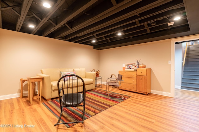 living area featuring stairway, wood finished floors, and baseboards
