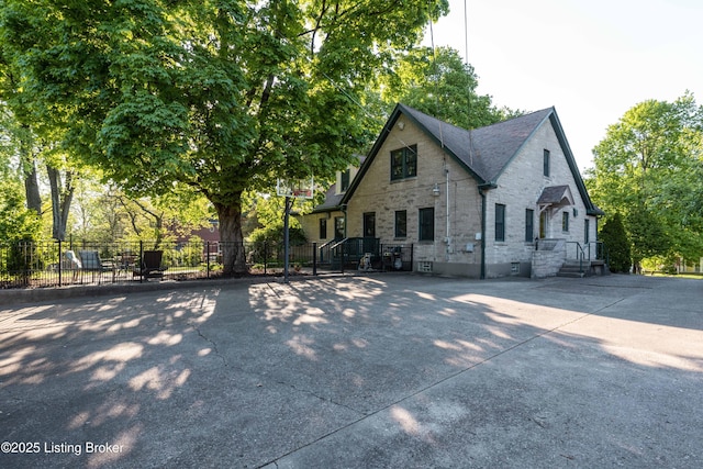 view of front of property with stone siding and fence