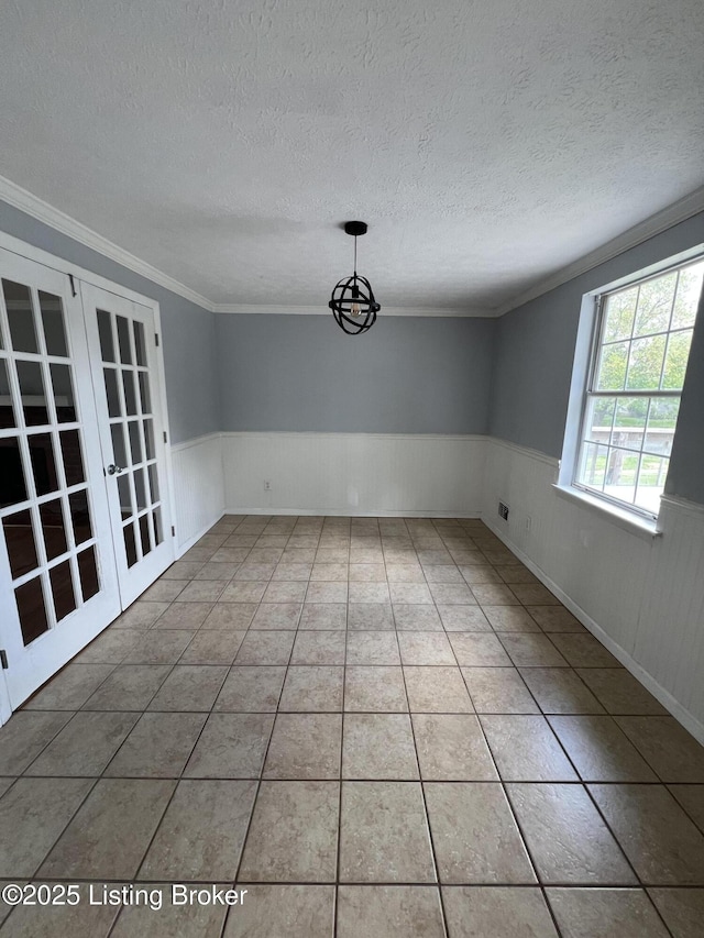 4213 Shenandoah Dr, Louisville, KY 40241 - unfurnished dining area featuring a textured ceiling, crown molding, french doors, tile patterned flooring, and wainscoting