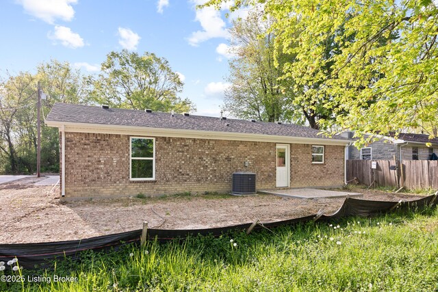 back of house featuring brick siding, central AC unit, a patio area, and fence