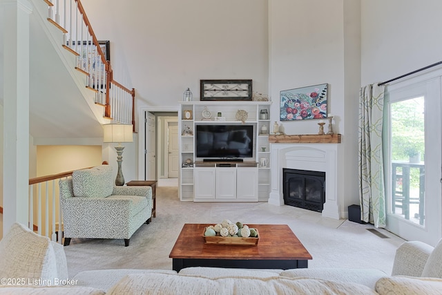 3817 Carriage Hill Dr, Crestwood, KY 40014 - living room with a high ceiling, light colored carpet, a fireplace with flush hearth, and stairs