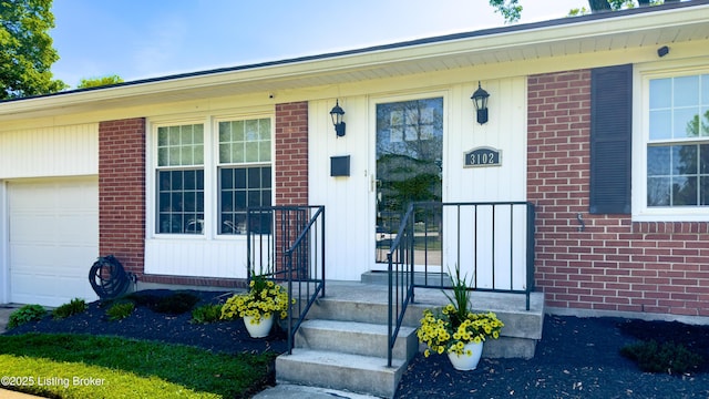entrance to property featuring brick siding and an attached garage