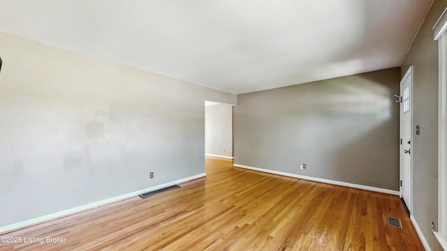 spare room featuring light wood-style floors, baseboards, and visible vents