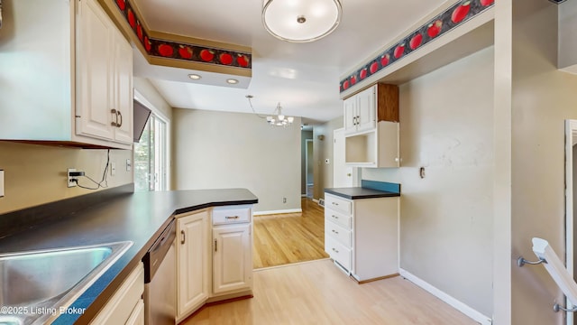 kitchen with light wood-style floors, dark countertops, baseboards, and stainless steel dishwasher