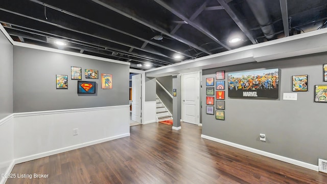 finished below grade area with visible vents, baseboards, wood finished floors, and stairway
