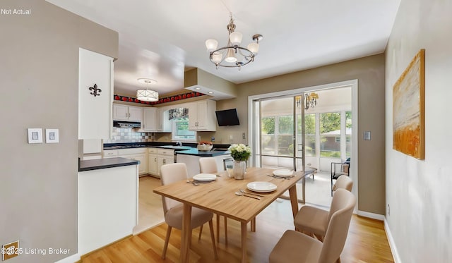 dining space with an inviting chandelier, baseboards, plenty of natural light, and light wood-style floors