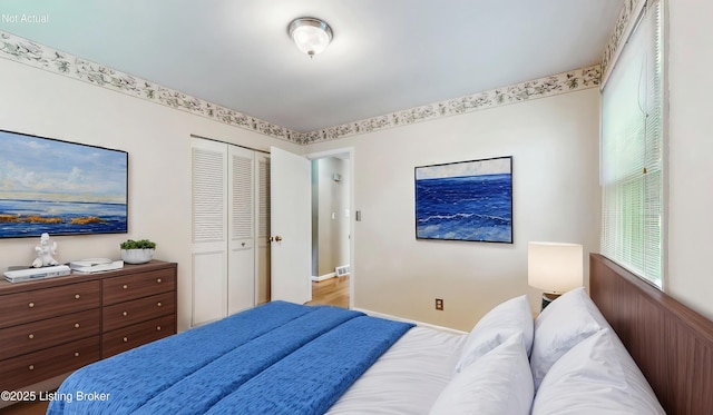 bedroom with baseboards, visible vents, and a closet